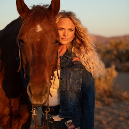 Singer Miranda Lambert standing with a horse.