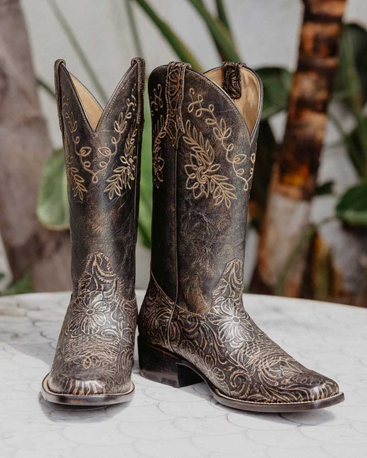 Black tooled boots on table.