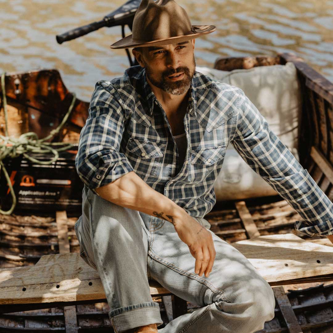 Man with cowboy hat and western plaid shirt