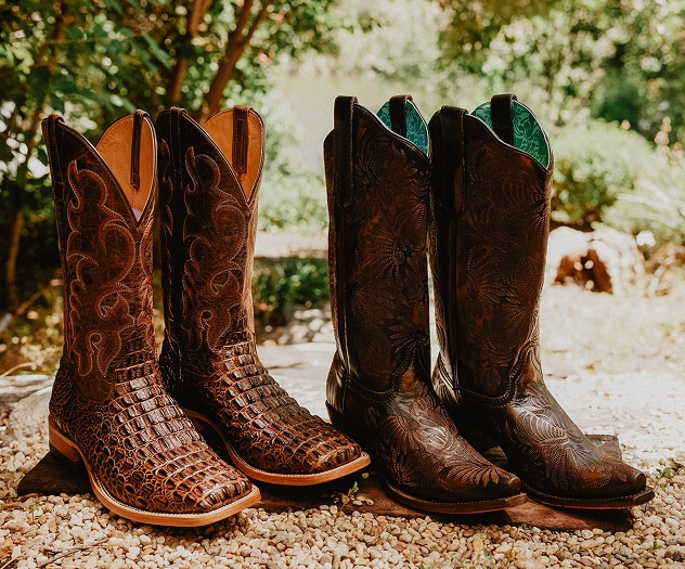 his and her brown boots on gravel