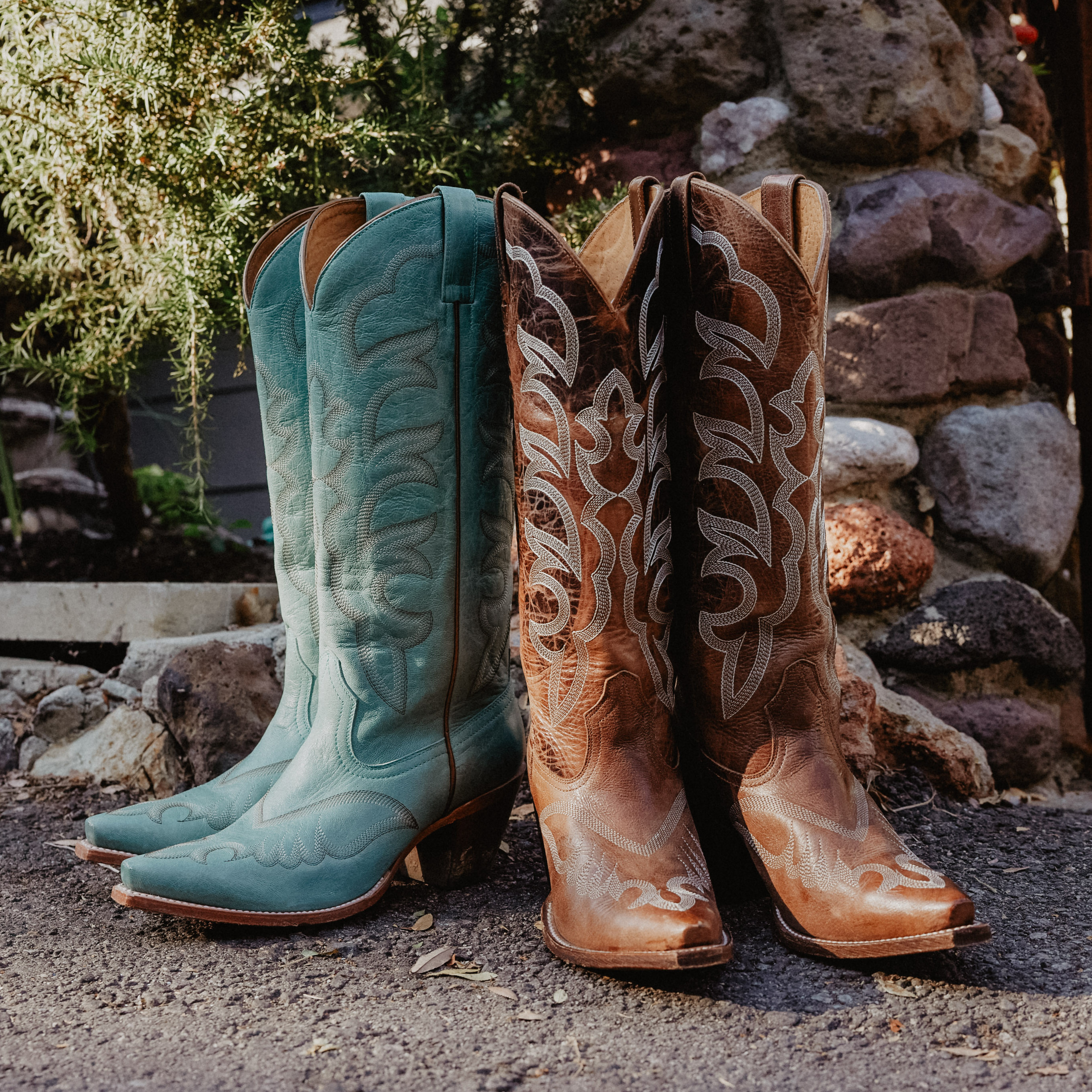 Women white boot and teal boot on ground.